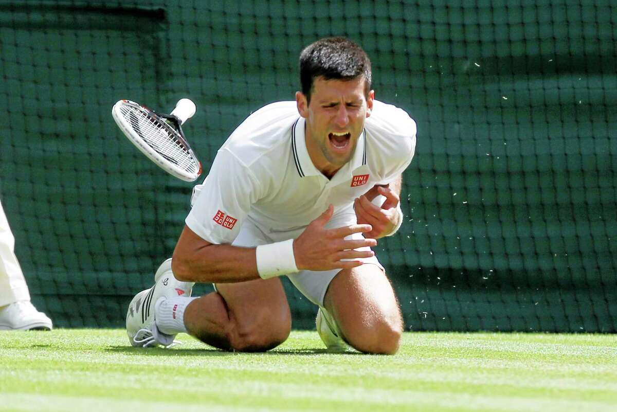 Novak Djokovic shouts in pain after falling onto the court during his match against Gilles Simon Friday at the All England Lawn Tennis Championships in Wimbledon, London.