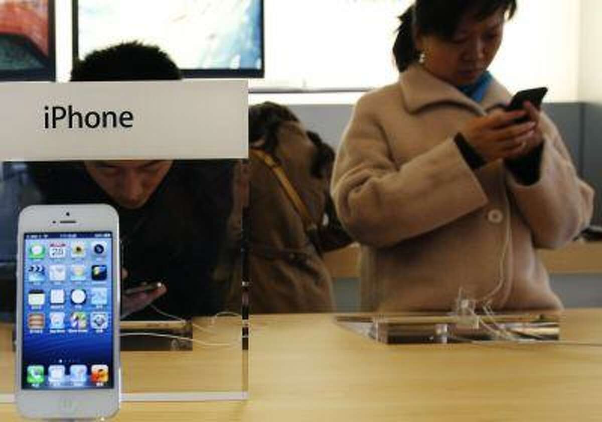Visitors try the iPhone at an Apple Store in Beijing.