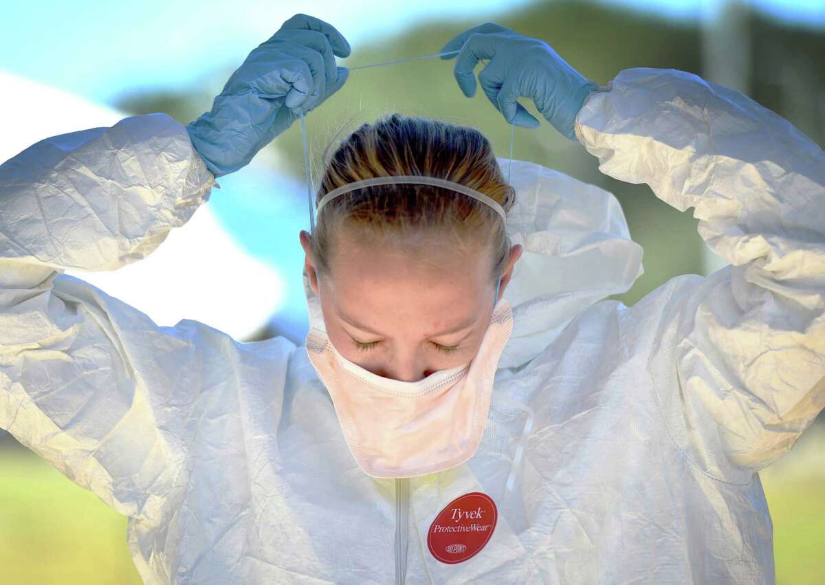 Senior Airman Laura Quick places a mask over her face on Wednesday Oct. 22, 2014, during an infectious disease training exercise for the Ebola virus on Eglin Air Force Base, Fla. Medical specialists on base perform the exercise with a different disease each year.