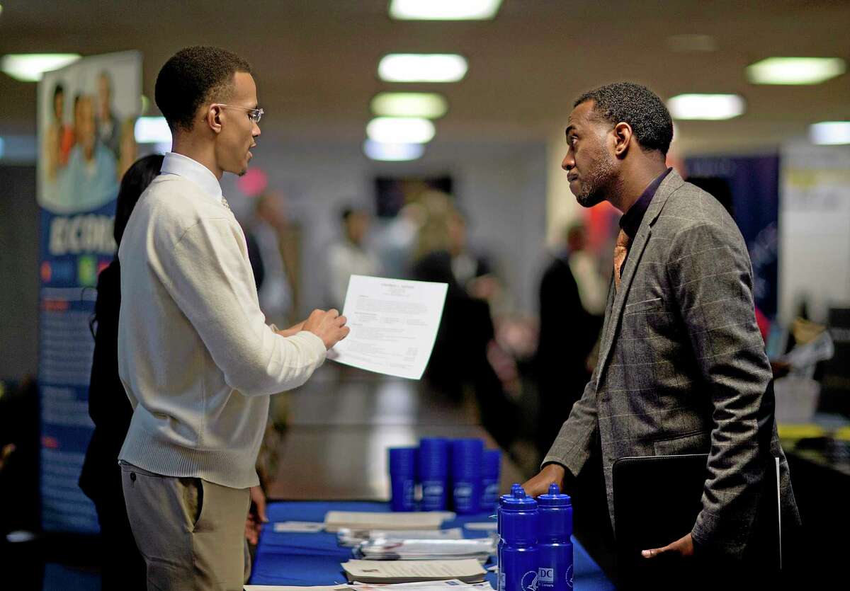 FILE - In this Thursday, Nov. 14, 2013, file photo, retired U.S. Air Force Master Sgt. Thomas Gipson, of Atlanta, right, has his resume looked over by Ralph Brown, a management and program analyst with the Centers for Disease Control and Prevention, during a job fair for veterans at the VFW Post 2681,Marietta, Ga. The Labor Department reports on the number of people who applied for U.S. unemployment benefits the first week of 2014 on Thursday, Jan. 9, 2014. AP Photo/David Goldman, File)