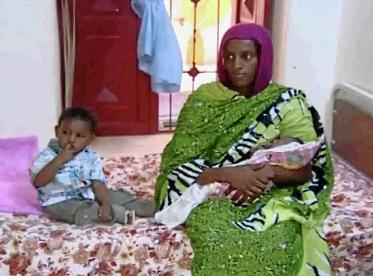 FILE - In this file image made from an undated video provided Thursday, June 5, 2014, by Al Fajer, a Sudanese nongovernmental organization, Meriam Ibrahim, sitting next to Martin, her 18-month-old son, holds her newborn baby girl that she gave birth to in jail last week, as the NGO visits her in a room at a prison in Khartoum, Sudan. Sudan's official news agency, SUNA, said the Court of Cassation in Khartoum on Monday, June 23, canceled the death sentence against 27-year-old Meriam Ibrahim after defense lawyers presented their case. The court ordered her release. (AP Photo/Al Fajer, File)