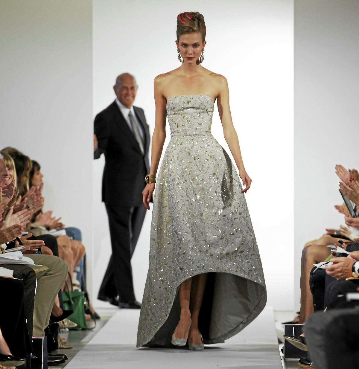 In this Sept. 11, 2012 photo, fashion designer Oscar de la Renta watches as the final model walks the runway during the presentation of his Spring 2013 collection at Fashion Week in New York.