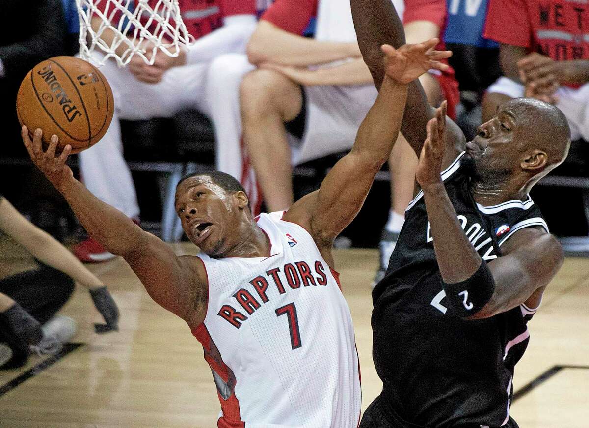 In this May 4 file photo, Toronto Raptors guard Kyle Lowry, left, gets fouled by Brooklyn Nets forward Kevin Garnett.