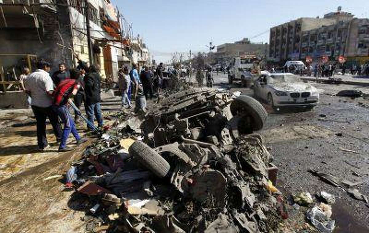 Residents gather at the site of a car bomb attack in the AL-Mashtal district in Baghdad March 19, 2013. A series of coordinated car bombs and blasts hit Shi'ite districts across Baghdad and south of the Iraqi capital on Tuesday, killing at least 25 people on the tenth anniversary of the U.S.-led invasion. REUTERS/Mohammed Ameen (IRAQ - Tags - Tags: CONFLICT CIVIL UNREST TPX IMAGES OF THE DAY)