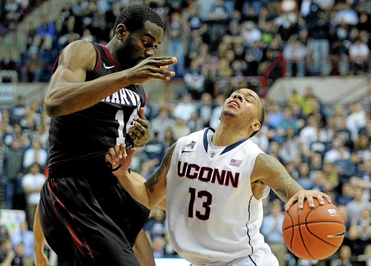 UConn’s Shabazz Napier (13) drives past Harvard’s Steve Moundou-Missi (14) during the second half of Connecticut’s 61-56 victory.