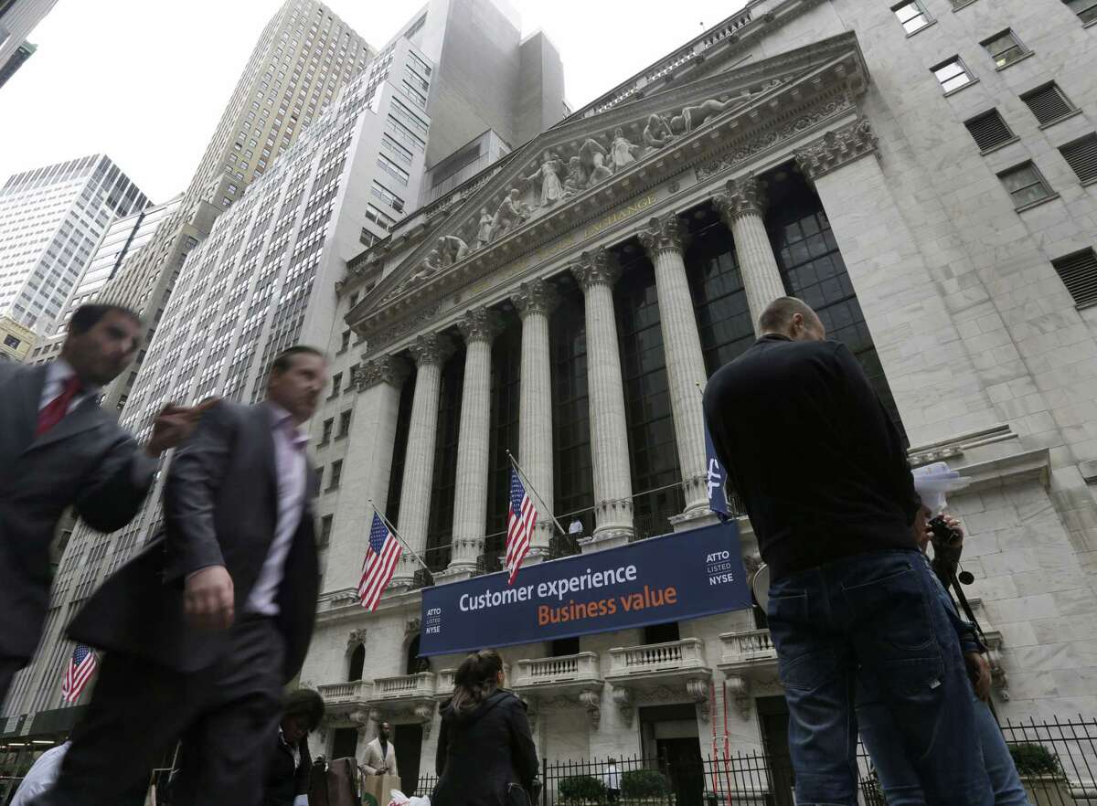 People pass the New York Stock Exchange in New York.