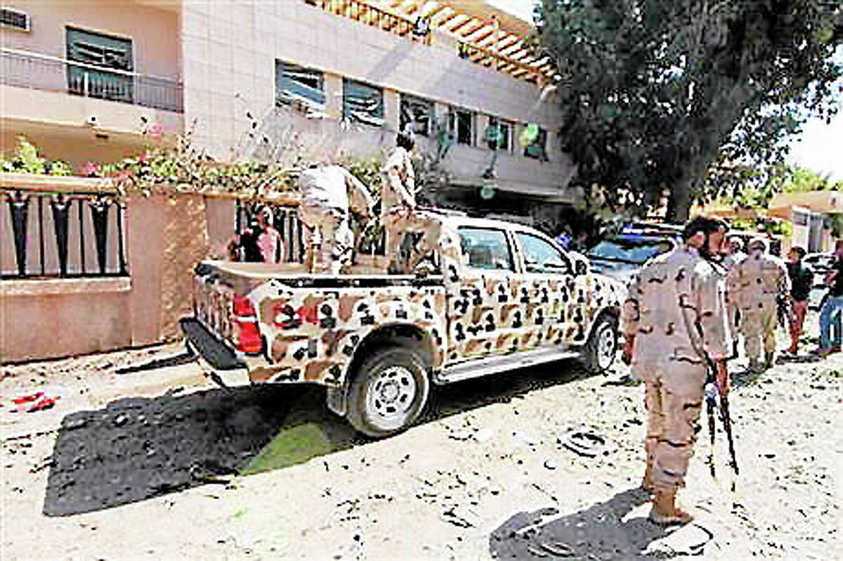 Security forces work at the site where a car bomb went off outside the building housing Swedish and Finnish consulates on Friday, Oct. 11, 2013 in Libya's eastern city of Benghazi, badly damaging the building, but leaving no casualties. Benghazi has been hit by a wave of attacks against government offices and targeted killings in recent months as security agencies struggle to secure Libya since the 2011 civil war. Weapons have proliferated and a number of militias have vied for authority, operating with impunity.(AP Photo/Mohammed el-Shaiky)