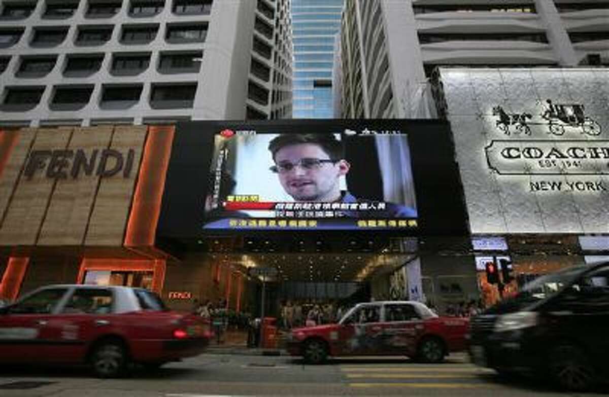 A TV screen shows a news report June 23 of Edward Snowden, a former CIA employee who leaked top-secret documents about sweeping U.S. surveillance programs, at a shopping mall in Hong Kong.