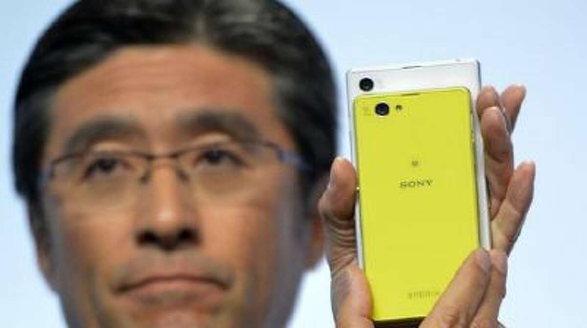 Kunimasa Suzuki, executive vice president of Sony Corporation and president and chief executive officer of Sony Mobile Communications, unveils the new Sony EXPERIA Z1 Compact during the Sony news conference at the International Consumer Electronics Show Monday, Jan. 6, 2014, in Las Vegas.
