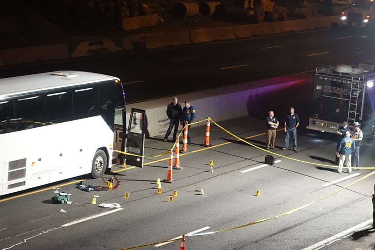 Law enforcement investigates the scene of a stabbing aboard a tour bus late Tuesdayin Norwalk. A man who stabbed passengers on the casino-bound tour bus on Interstate 95 was fatally shot by a state trooper, state police said Wednesday.