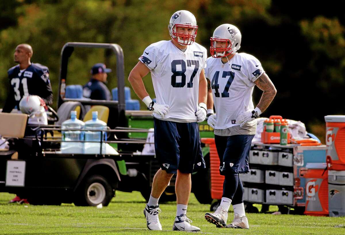 New England Patriots tight ends Rob Gronkowski (87) and Michael Hoomanawanui (47) go through a stretching and drills session before practice at the team’s facility Wednesday in Foxborough, Mass.