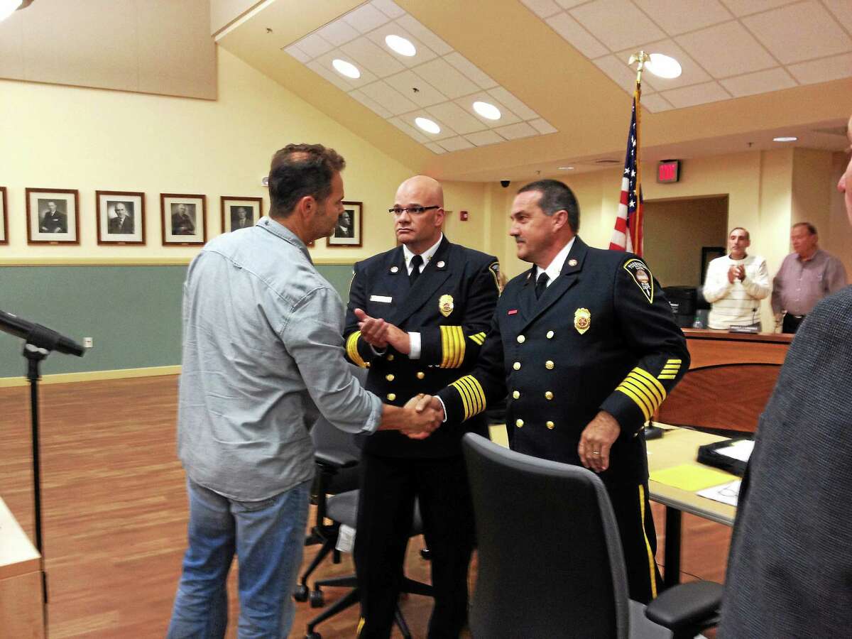 Torrington firefighter Mark Garrison shakes hands with Torrington Fire Chief Gary Brunoli after being promoted from firefighter to lieutenant Wednesday. His promotion was one of nine made by the fire and police departments.
