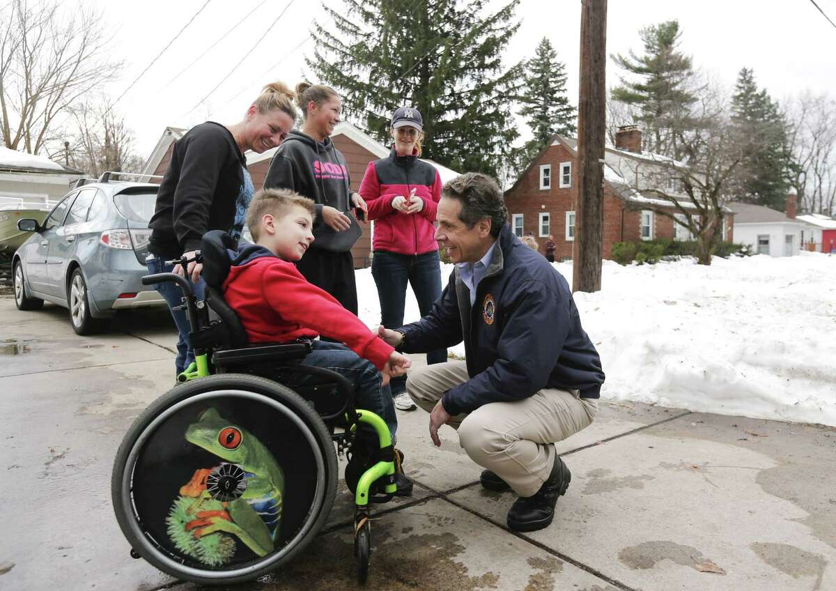 New York Gov. Andrew Cuomo greets Charlie Kelly III while surveying the aftermath of last week's lake-effect snowstorms on Monday, Nov. 24, 2014, in West Seneca, N.Y. Also pictured are is Charlie's mother Jodi Kelly and neighbors Kendyl Williams and Jen McNaughton. (AP Photo/Mike Groll)