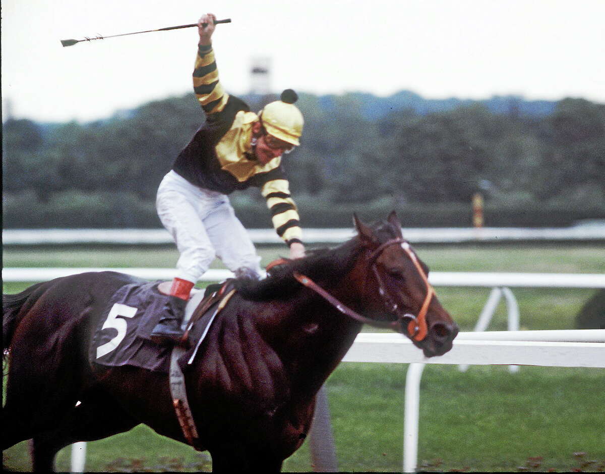 Jockey Jean Cruget stands up in his saddle and celebrates after guiding Seattle Slew to victory in the Belmont Stakes at Belmont Park in Elmont, N.Y. on June 11, 1977. The win gives Slew horse racing’s Triple Crown.