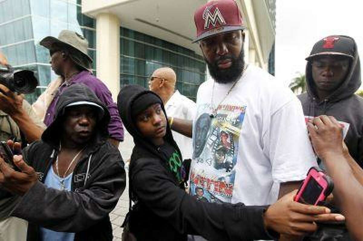 Tracy Martin,second right, father of Trayvon Martin, is surrounded by members of the crowd before a group photo during a rally for his son in Miami, Florida July 20, 2013.