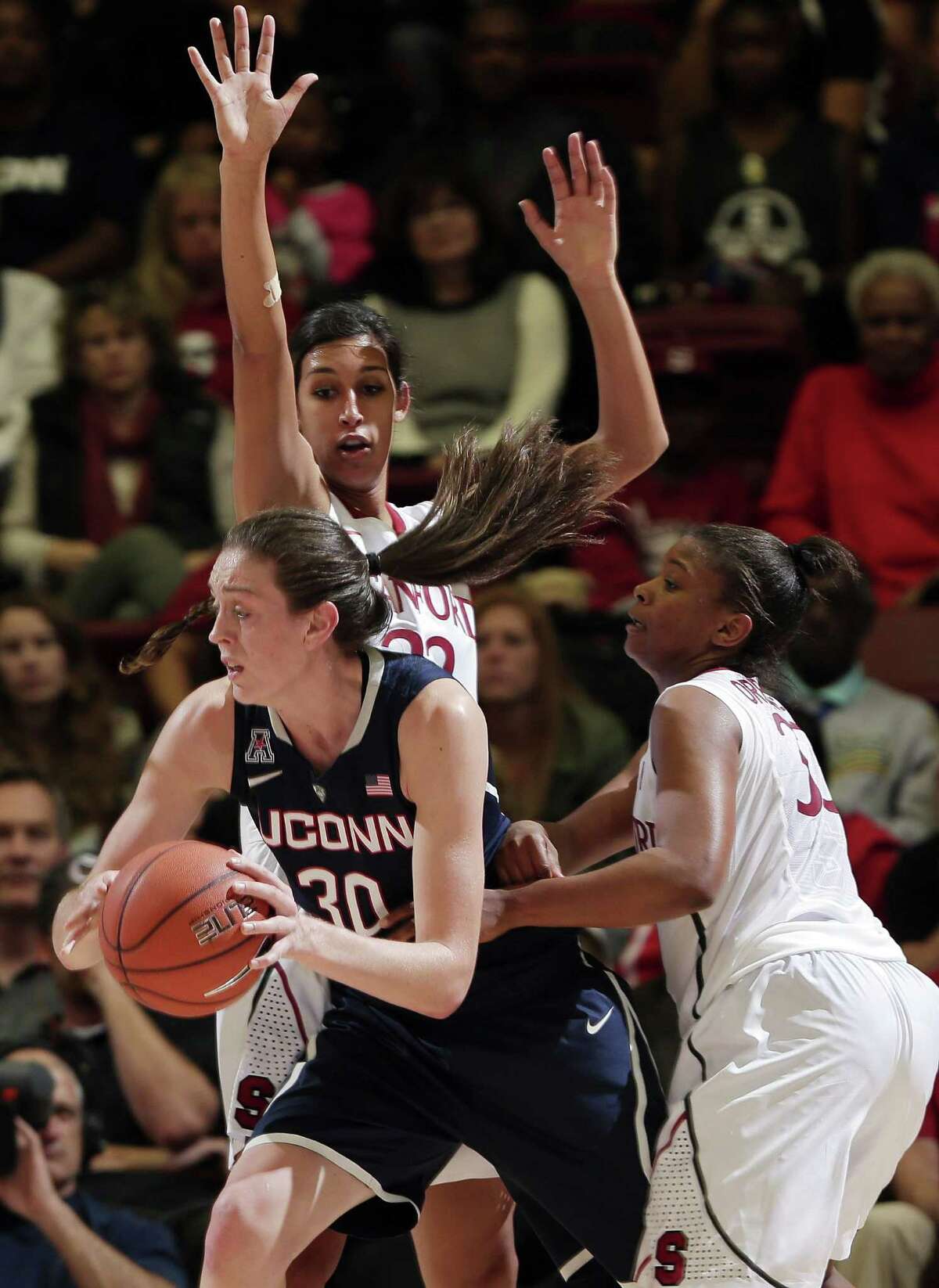 Connecticut forward Breanna Stewart (30) is guarded by Stanford forward Kailee Johnson, top, and guard Amber Orrange, right, during the second half of an NCAA college basketball game on Monday, Nov. 17, 2014, in Stanford, Calif. Stanford won 88-86 in overtime. (AP Photo/Marcio Jose Sanchez)