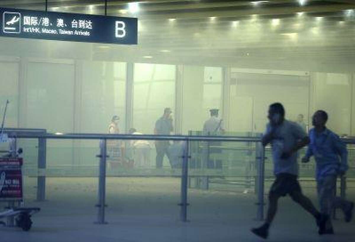 In this photo released by China's Xinhua News Agency, medical workers and policemen work at the terminal 3 of the Beijing International Airport in Beijing, Saturday, July 20, 2013.