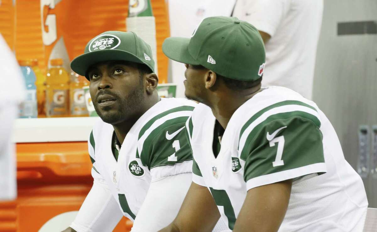 Jets quarterbacks Michael Vick (1) and Geno Smith (7) are seen on the bench during the second half Monday night.