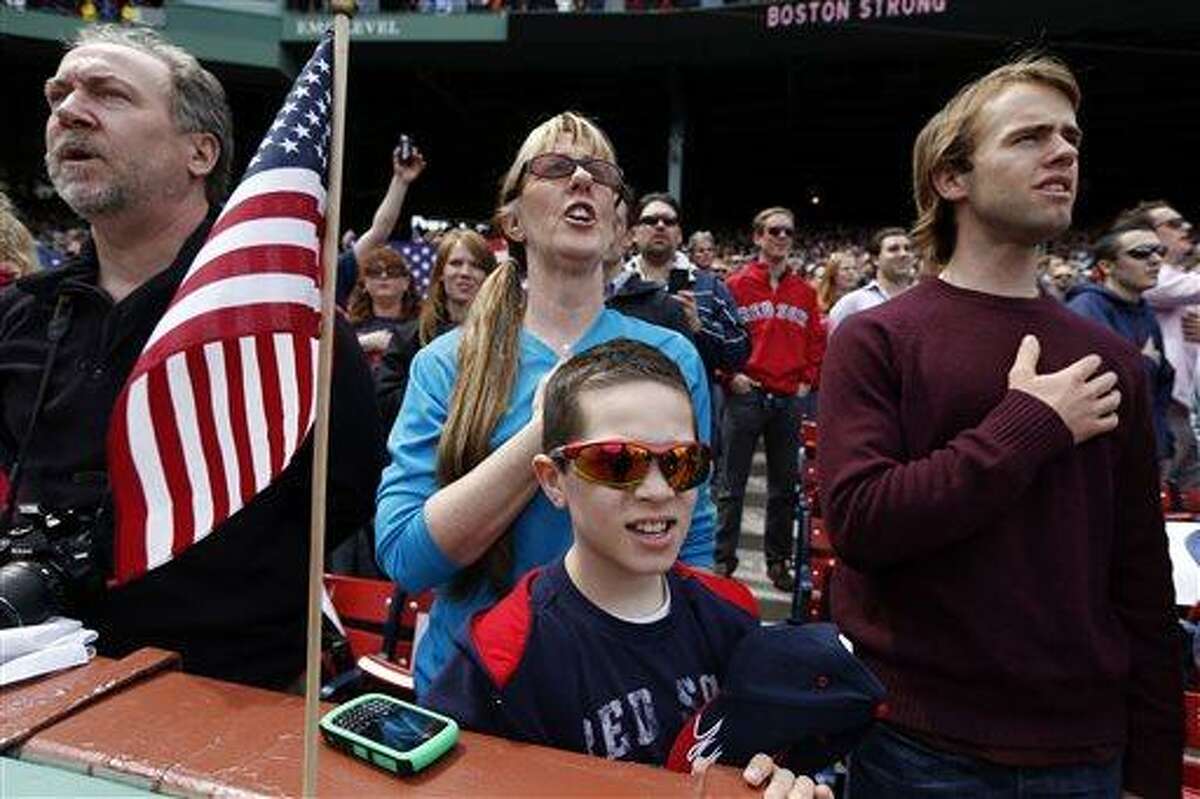 Fans, accompanied by the stadium organist, sing the national anthem before a baseball game between the Boston Red Sox and the Kansas City Royals in Boston, Saturday, April 20, 2013. (AP Photo/Michael Dwyer)