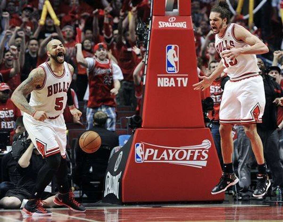 Chicago Bulls' Carlos Boozer (5) and Joakim Noah (13) celebrate a basket against the Brooklyn Nets during the second overtime in Game 4 of their first-round NBA basketball playoff series Saturday, April 27, 2013, in Chicago. The Bulls won 142-134 in three overtimes. (AP Photo/Jim Prisching)