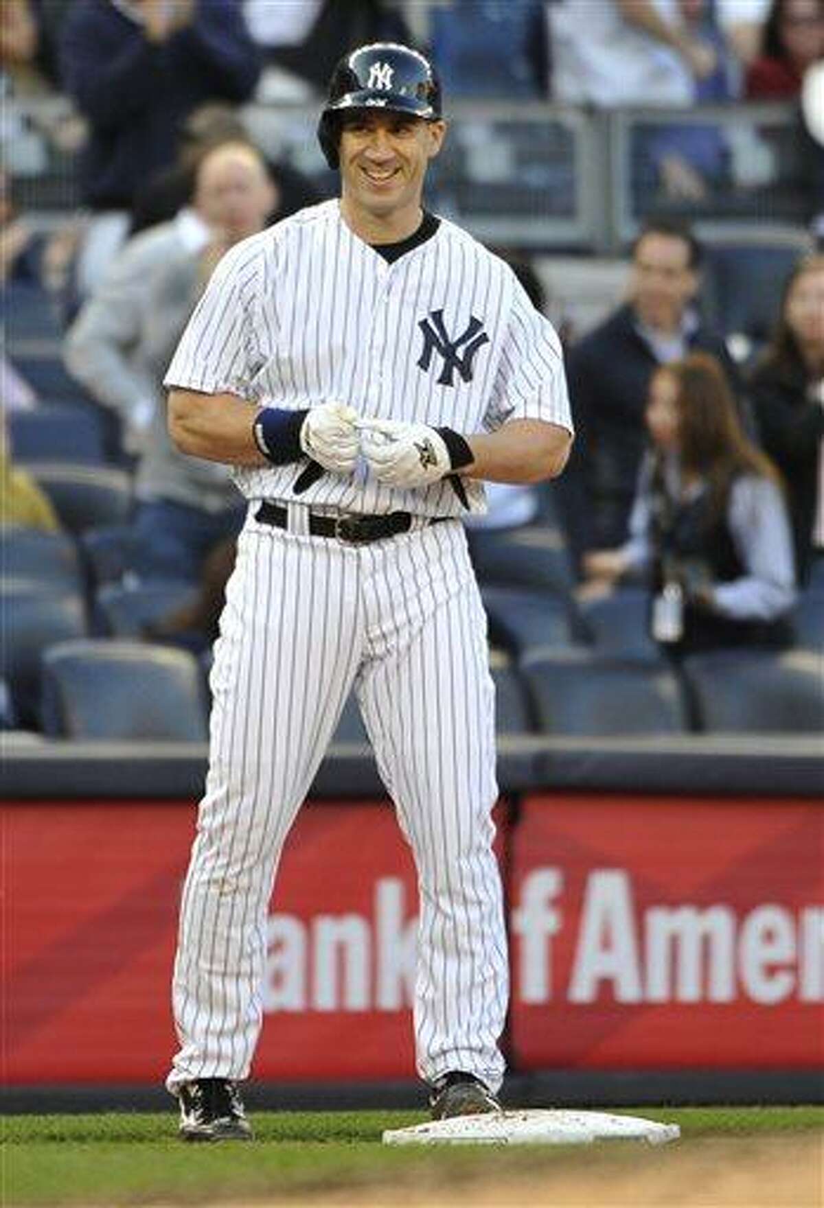 New York Yankees designated hitter Travis Hafner smiles at third base after he hit an RBI triple off of Toronto Blue Jays relief pitcher Brett Cecil in the seventh inning of a baseball game at Yankee Stadium on Saturday, April 27, 2013 in New York. Haffner also hit a three-run home run in the fourth inning. (AP Photo/Kathy Kmonicek)
