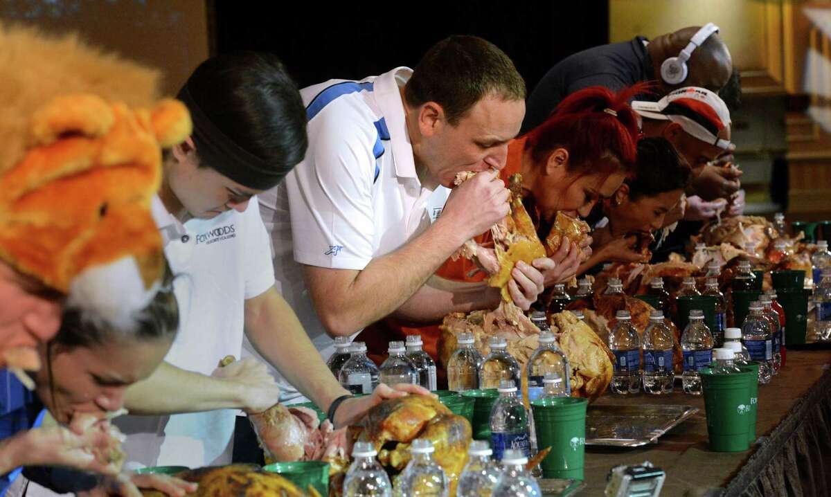 Joey Chestnut, center, and the other eaters participate Saturday in the World Turkey-Eating Championship at Foxwoods Resort and Casino in Mashantucket, Conn. Chestnut won the contest in Connecticut, setting a record by devouring an entire bird.