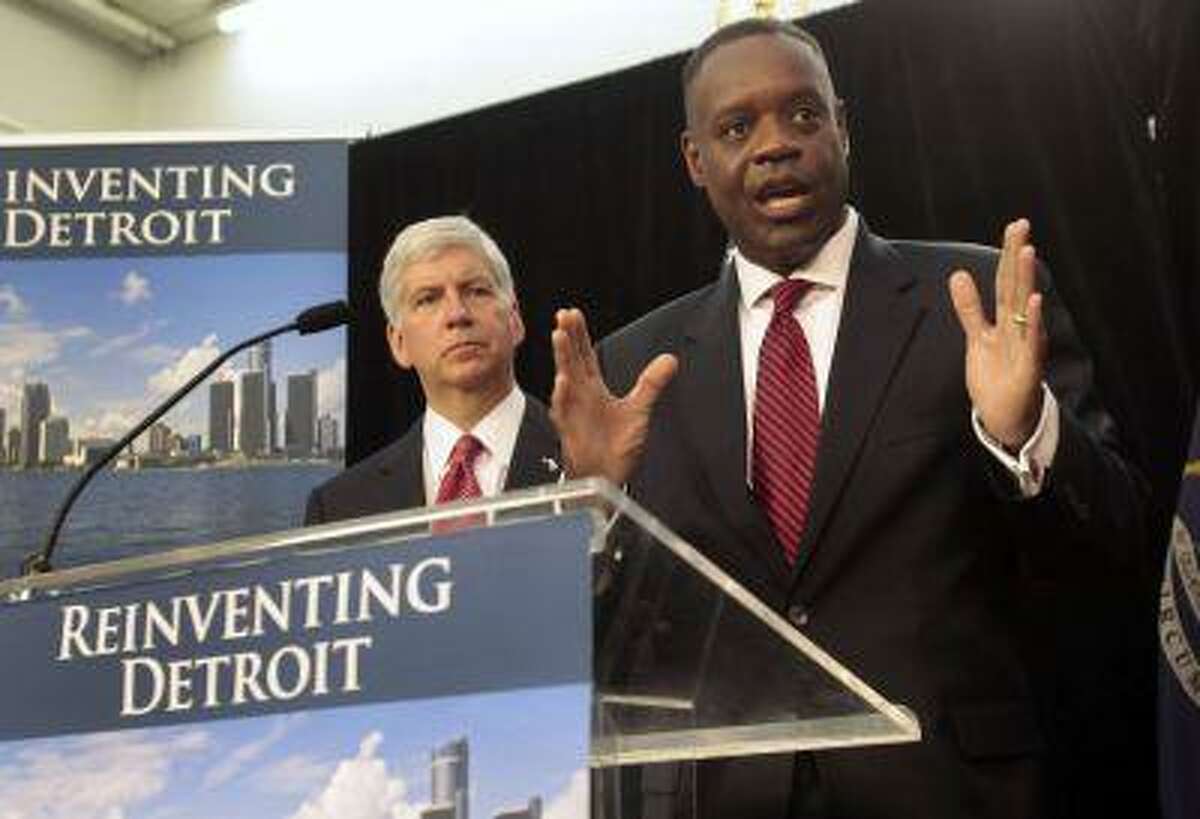 Detroit Emergency Manager Kevyn Orr addresses the media as Michigan Governor Rick Snyder listens during a news conference about filing bankruptcy for the city of Detroit in Detroit, Michigan July 19, 2013.