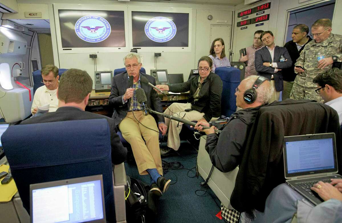 U.S. Defense Secretary Chuck Hagel, center, is seen aboard a U.S. Military Aircraft before speaking to members of the media during his flight, Sunday, June 1, 2014. Hagel spoke about the released of U.S. Army Sgt. Bowe Bergdahl who was held hostage in Afghanistan, and who was handed over Saturday morning by members of the Taliban in exchange for five Afghan detainees held at the military prison in Guantanamo Bay prison in Cuba.