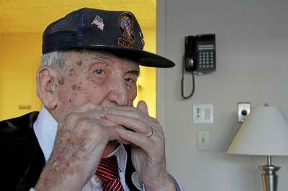 ESTEBAN L. HERNANDEZ/REGISTER CITIZEN William "Bill" Linden plays his harmonica on Saturday, April 27, 2013, as he celebrated his 100th birthday at Litchfield Woods Health Care Center in Torrington. More than 30 of his family members and close friends were in attendance.