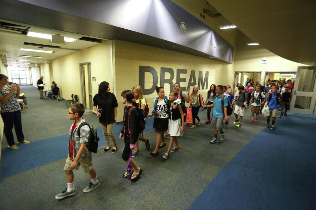 In this Sept. 3, 2014 photo, fifth grade students walk to their classroom for the first time in their new school Plum Creek Elementary in Hutchinson, Kan. A state district court panel expects to rule by late December on whether Kansas is spending enough money on its public schools to provide an adequate education to every child, and even before there's an answer, the lawsuit itself is complicating efforts to close the state's budget shortfalls. (AP Photo/The Hutchinson News, Travis Morisse)