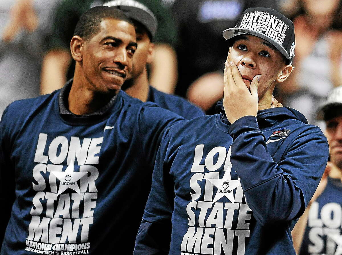 Connecticut’s Shabazz Napier, right, reacts as his name is revealed on the Huskies Wall of Honor as coach Kevin Ollie, left, looks over at Napier during a pep rally celebrating Connecticut’s fourth NCAA men’s basketball championship on April 8, 2014, in Storrs, Conn.