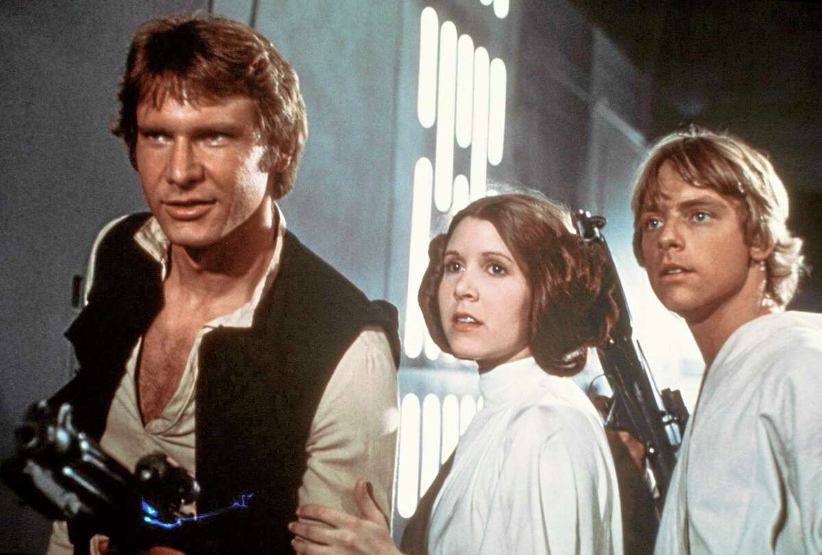 In this 1977 image provided by 20th Century-Fox Film Corporation, from left, Harrison Ford, Carrie Fisher, and Mark Hamill are shown in a scene from "Star Wars" movie released by 20th Century-Fox. From the set of ìStar Wars: Episode VIIî in Abu Dhabi, director J.J. Abrams announced the launch of Star Wars: Force for Change, a campaign to raise funds for United Nations Childrenís Fundís (UNICEF). The campaign will run from 12:01 a.m. PDT on May 21, 2014, until 11:59 p.m. PDT on July 18. (AP Photo/20th Century-Fox Film Corporation)