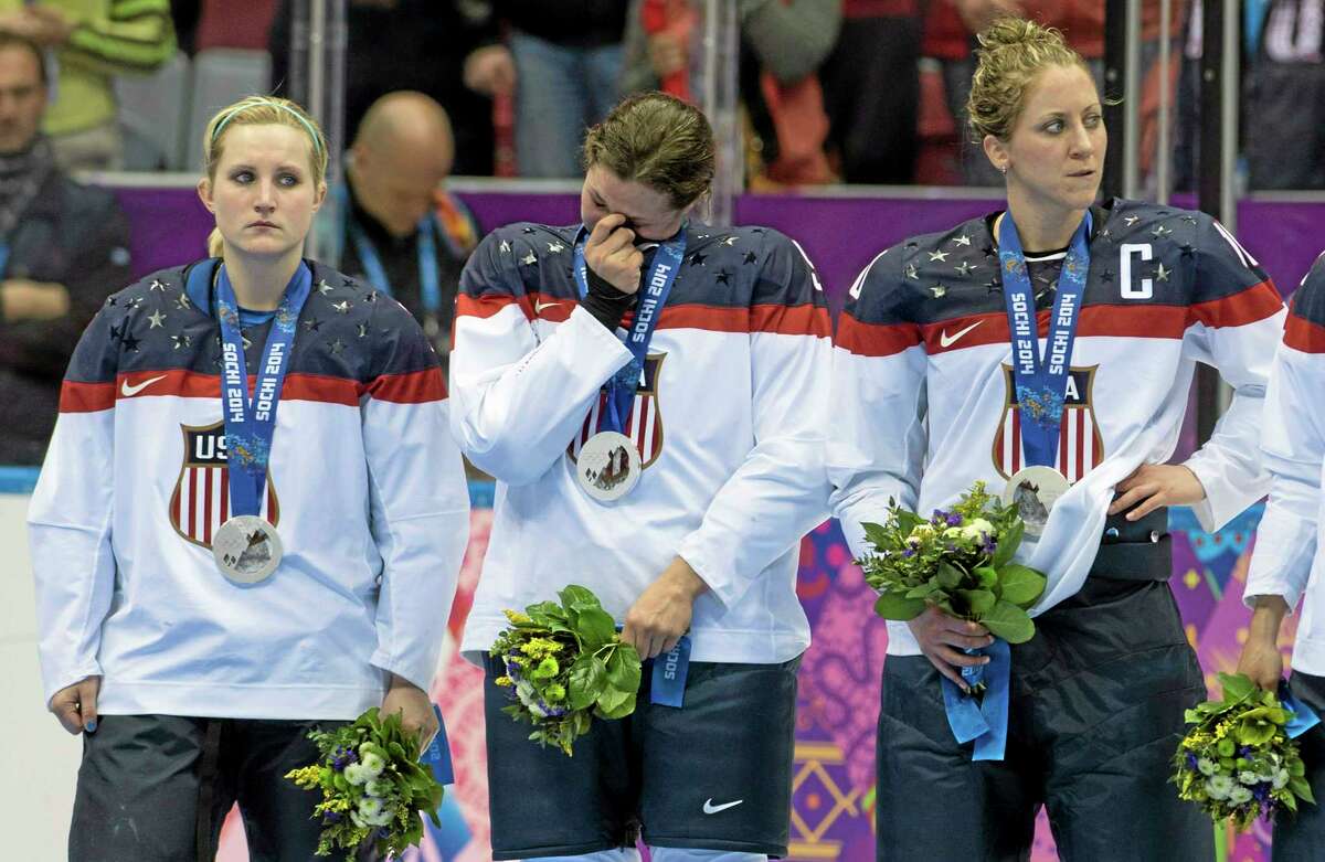 United States women’s hockey players, from left, Monique Lamoureux, Megan Bozek and Meghan Duggan, react after losing 3-2 in overtime to Canada in the gold-medal game Thursday at Winter Olympics in Sochi, Russia.