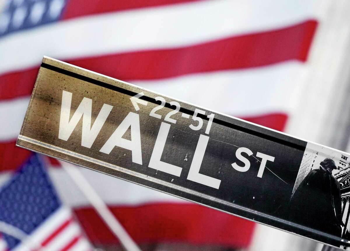 This Aug. 9, 2011, photo shows a Wall Street street sign near the New York Stock Exchange, in New York. U.S. stock futures are heading lower in early trading Tuesday, June 3, 2014, a day after major indexes reached new highs. (AP Photo/Mark Lennihan, File)