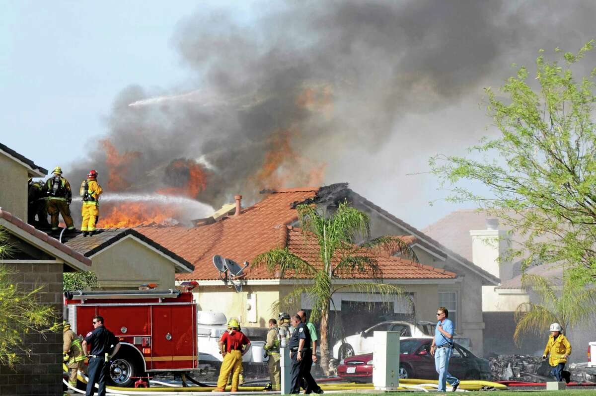 This photo shows the site of a military jet that crashed on a residential street in the desert community of Imperial, Calif., setting two homes on fire Wednesday, June 4, 2014. Lance Cpl. Christopher Johns, a U.S. Marines spokesman, says the jet was a Harrier from Marine Corps Air Station in Yuma, Arizona. (AP Photo/The Imperial Valley Press, Chelcey Adami)