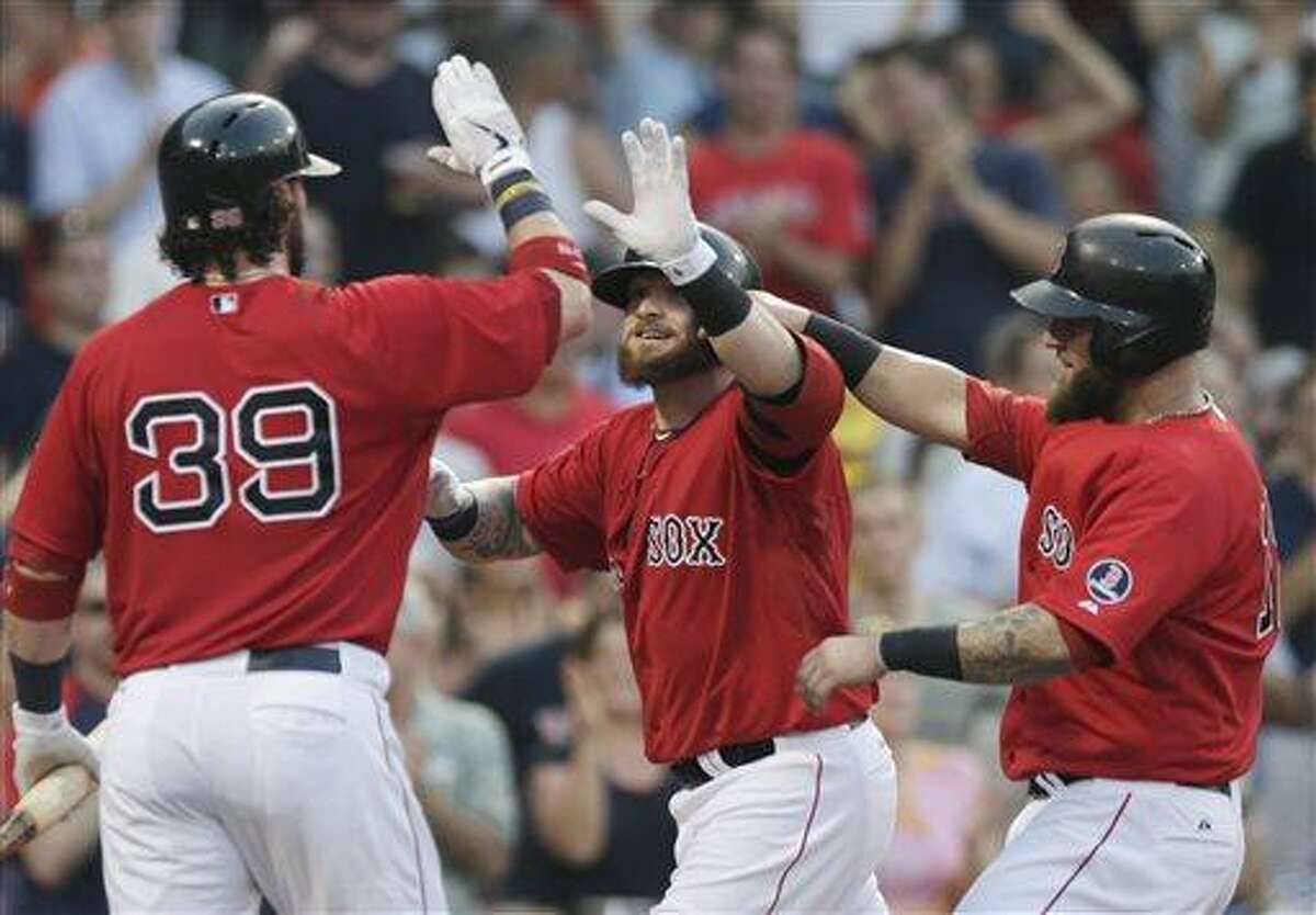 Boston Red Sox's Jonny Gomes, center, is congratulated by Jarrod Saltalamacchia, left, and Mike Napoli after his two-run home run off New York Yankees starting pitcher Andy Pettitte during the second inning of a baseball game at Fenway Park, Friday, July 19, 2013, in Boston. (AP Photo/Charles Krupa)