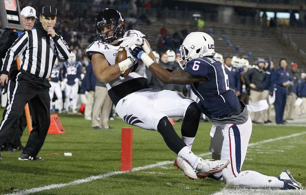 Cincinnati tight end Jake Golic, second from right, comes down with the touchdown reception against UConn cornerback Jhavon Williams (6) during the first half Saturday.