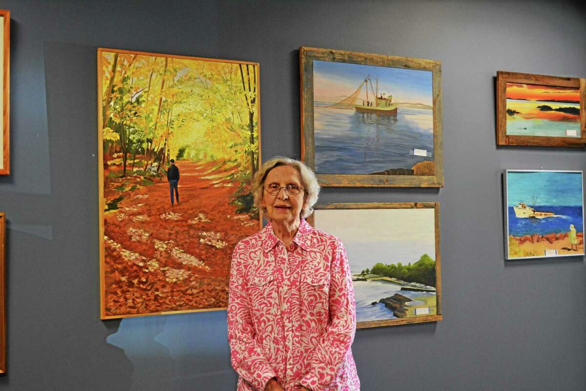 Jenny Golfin - The Register Citizen. The June Artist of the Month poses in front of her works on display for the month.