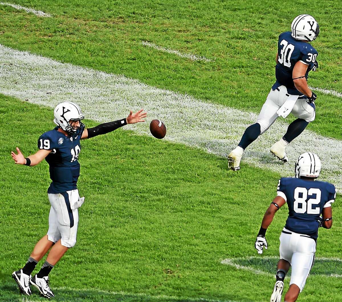 Yale quarterback Morgan Roberts, left, celebrates with teammate Tyler Varga, center, after he scored a touchdown against Lehigh during a Sept. 20 game at Yale Bowl.