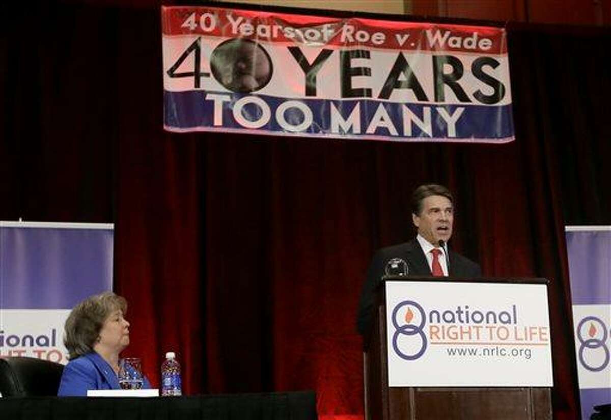 Carol Tobias, president of National Right To Life, left, watches as Gov. Rick Perry delivers a speech to a large audience in attendance at the national convention, Thursday, June 27, 2013, in Grapevine, Texas. The Republican has called a second special legislative session beginning July 1, allowing the GOP-controlled statehouse another crack at passing restrictions opponents say could shutter nearly all the abortion clinics across the country's second-largest state. (AP Photo/Tony Gutierrez)