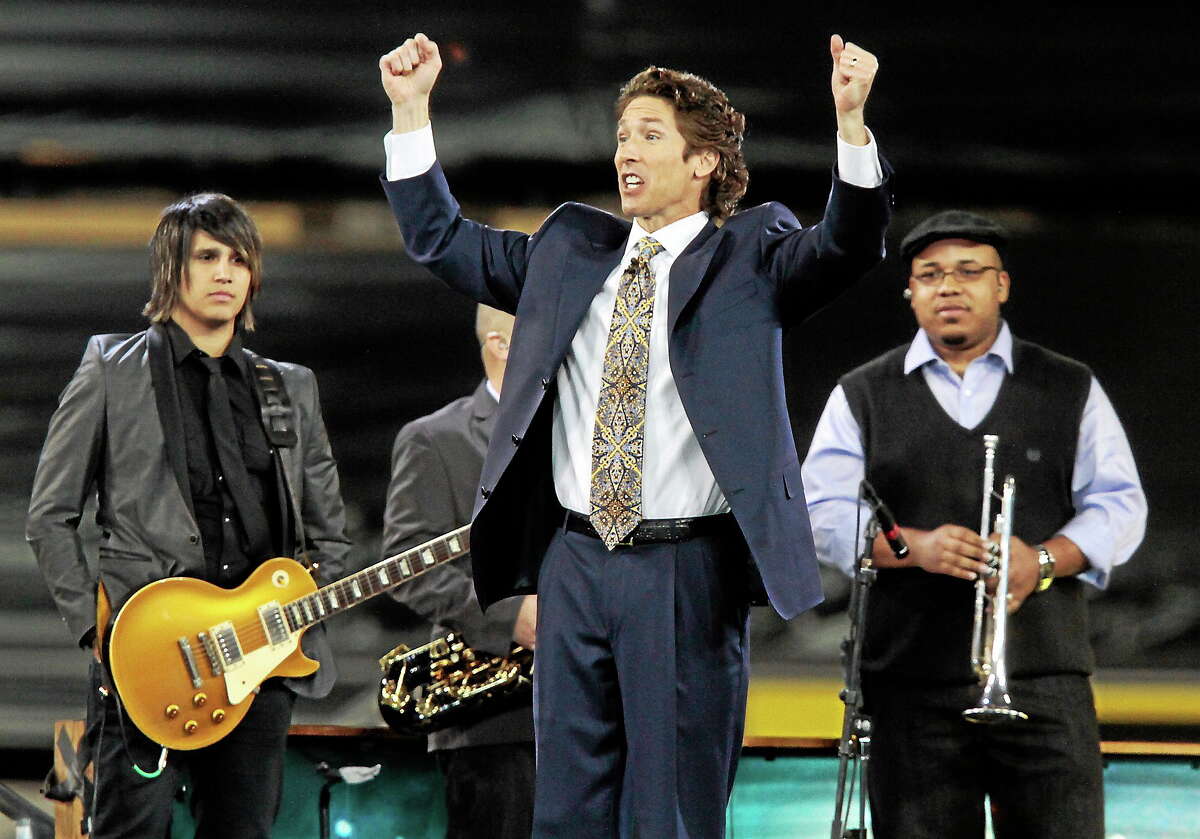 Lakewood Church pastor Joel Osteen, center, leads his congregation in prayer during his “A Night of Hope” event at Dodger Stadium on Saturday April 24, 2010.