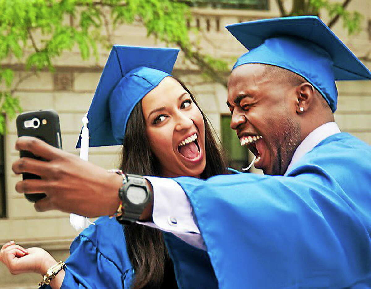Gateway graduates, Spenta Mehraban (L), and Adon Duncanson, take some selfies before commencement ceremonies at Woolsey Hall 5/22.