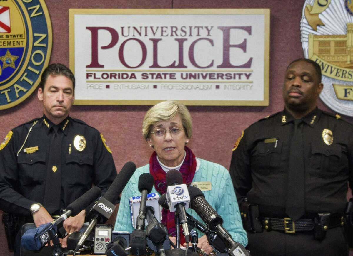 Mary Coburn, vice president of student affairs, center, talks to the media during a news conference about a shooting at the Strozier Library on the Florida State University campus, Thursday, Nov. 20, 2014, in Tallahassee, Fla. Three students were wounded and the gunman was shot and killed by police officers. Tallahassee police Chief Michael Deleo, left, and FSU police Chief David Perry stand in the background. (AP Photo/Mark Wallheiser)