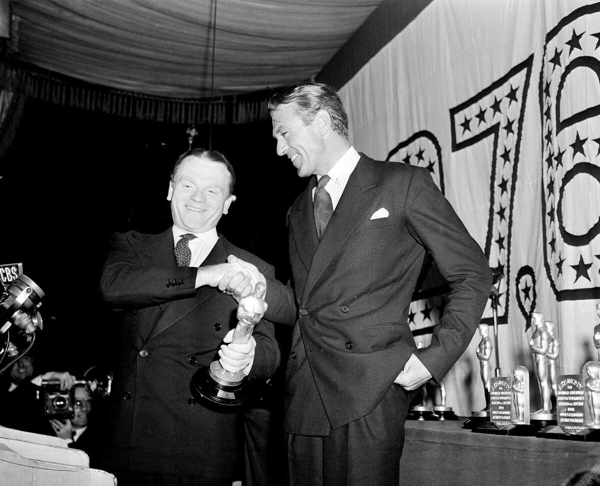 FILE-In this March 4, 1943 file photo, actor Jimmy Cagney, left, is congratulated by Gary Cooper after receiving the best actor Oscar statuette for his role in "Yankee Doodle Dandy" at the 1942 Academy Awards banquet at Cocoanut Grove, Ambassador Hotel, in Los Angeles. The auctioneer Nate D. Sanders will sell Cagney's Oscar statuette to the highest bidder on November 20, 2014. (AP Photo/John T. Burns, File)