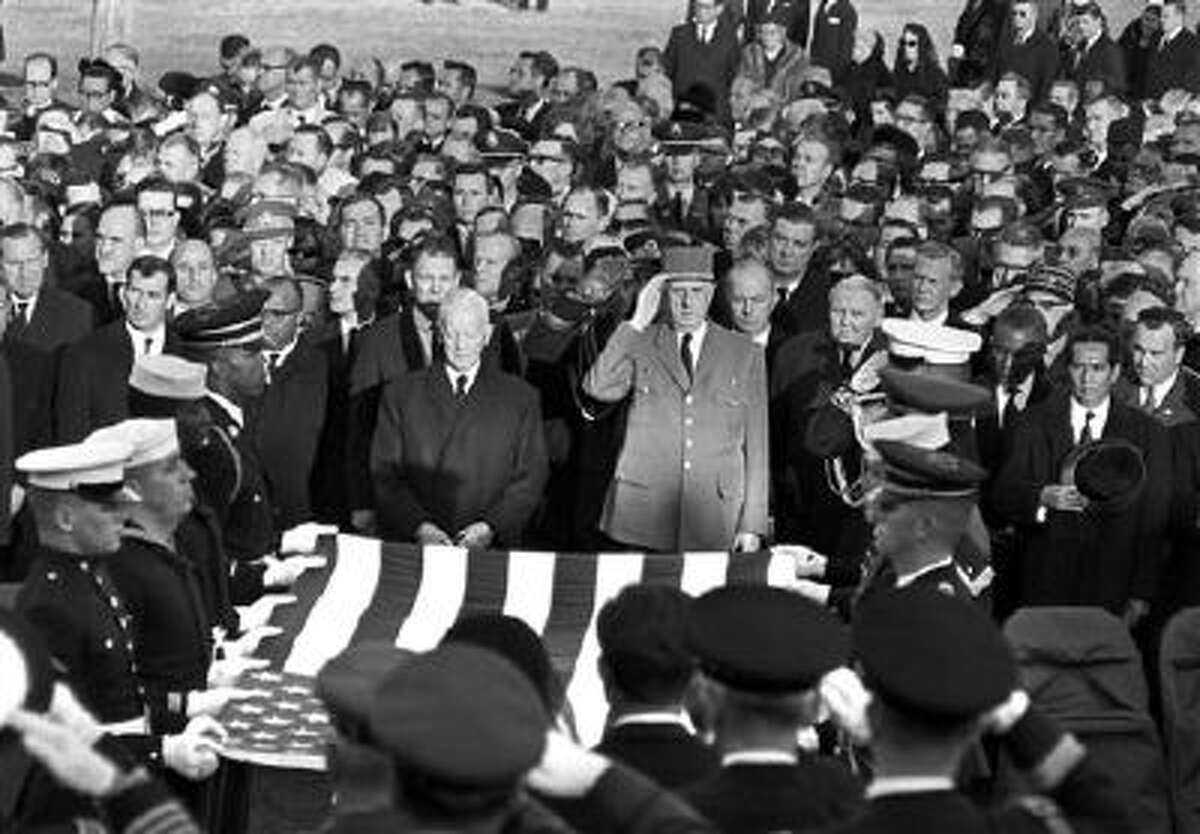 President Charles de Gaulle of France, center, and other dignitaries salute as servicemen hold an American flag above the casket of President John F. Kennedy in Arlington National Cemetery in Arlington, Va., on Nov. 25, 1963.