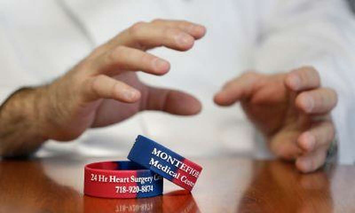 In this Thursday, Jan. 17, 2013 photo, Dr. Ricardo Bello talks about informational bracelets for heart patients at Montefiore Medical Center in New York. Bellow, a cardiac surgeon at the center, leads a program that aims to keep patients recovering from heart surgery from having to be rehospitalized. Patients wear a bracelet with a 24-hour phone number to call the cardiac unit at the first sign of problems. (AP Photo/Seth Wenig)