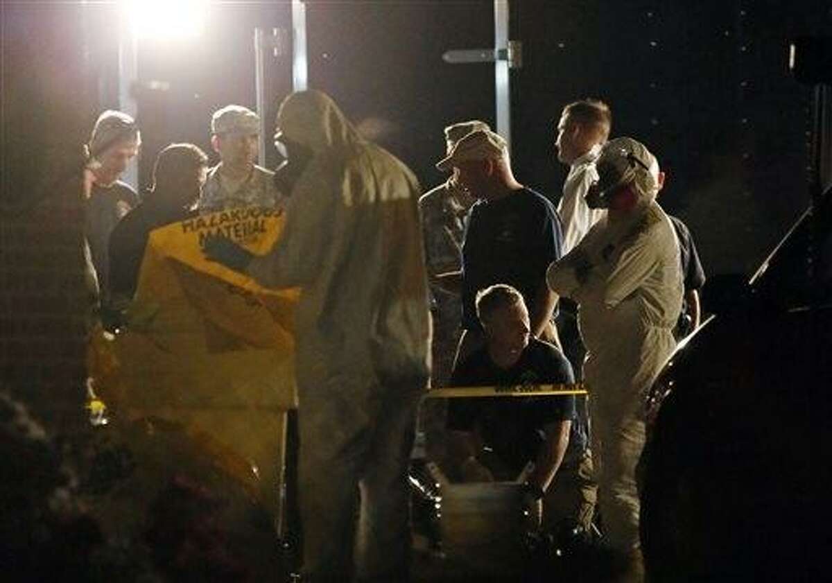 A federal agent wearing a hazmat suit secures a container used during a search of the Tupelo, Miss., home of Everett Dutschke, Tuesday, April 23, 2013 in connection with the recent ricin attacks. No charges have been filed against Dutschke and he hasn't been arrested. (AP Photo/Rogelio V. Solis)
