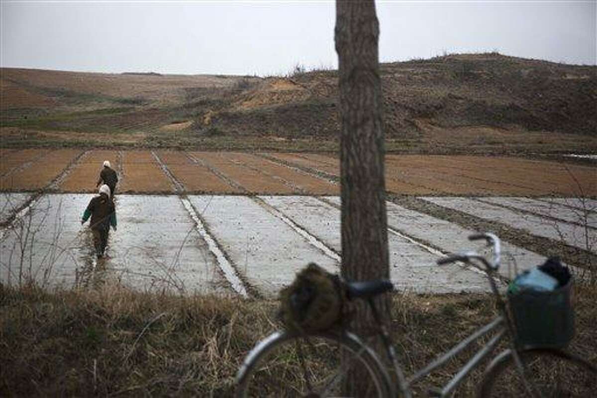 North Korean farmers work in a field inside the demilitarized zone which separates the two Koreas at Panmunjom, North Korea, Tuesday, April 23, 2013. (AP Photo/David Guttenfelder)