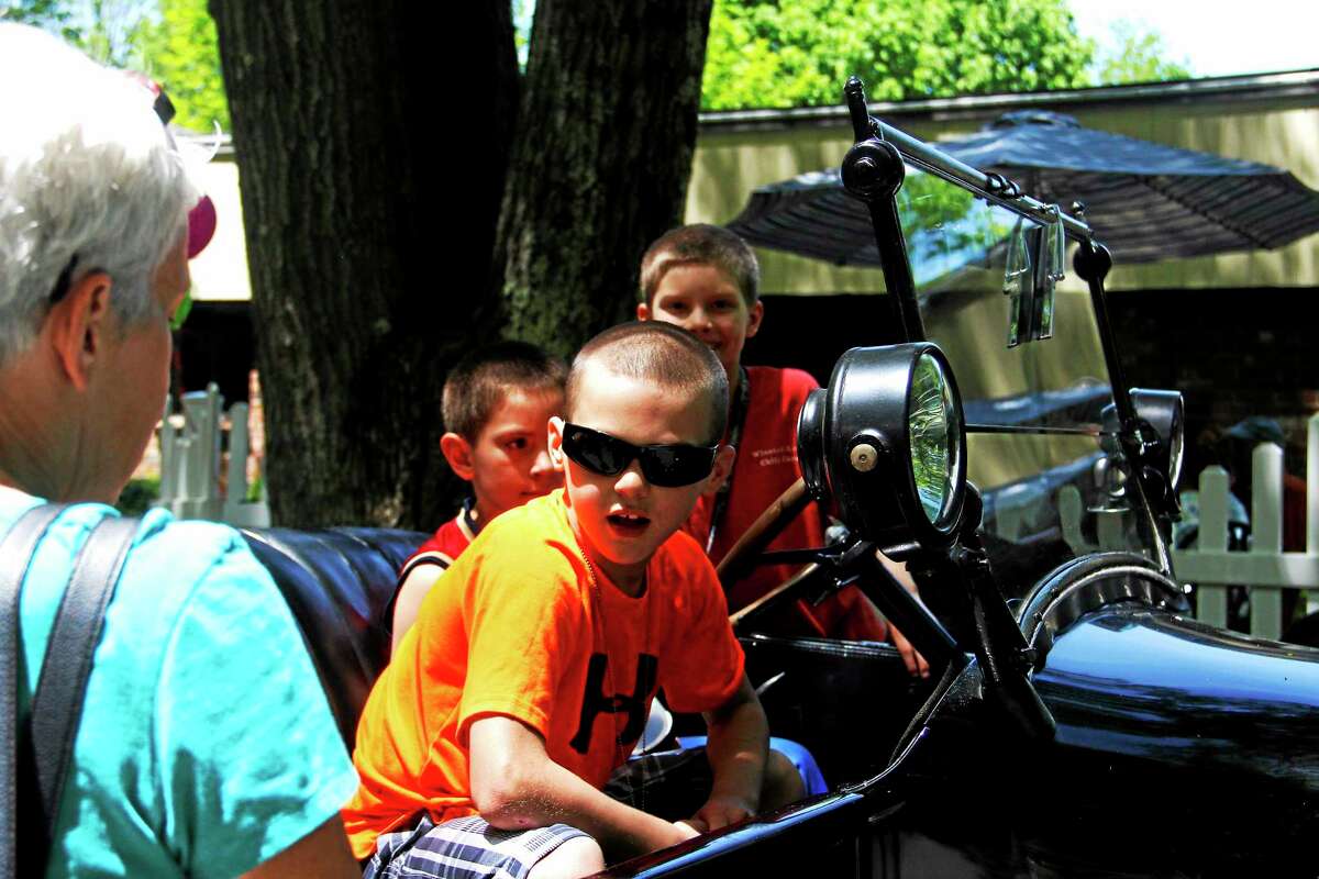 Children ride a vintage automobile during the Touch-A-Truck event at Torrington Health and Rehab on Sunday, June 1, 2014.