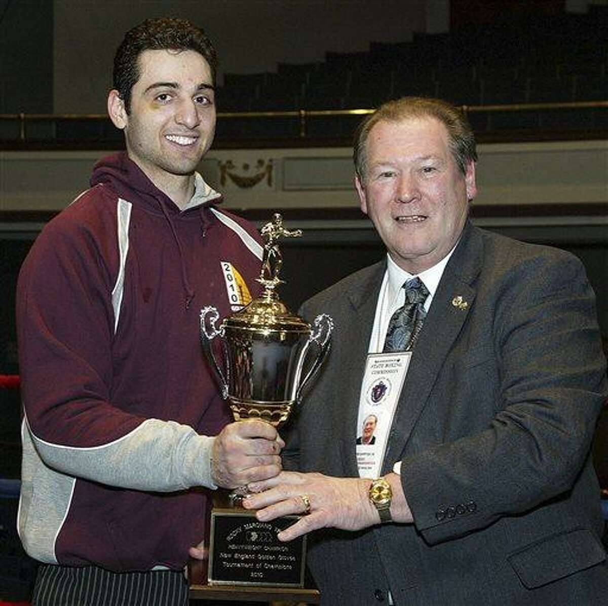 In this Feb. 17, 2010, photo, Tamerlan Tsarnaev, left, accepts the trophy for winning the 2010 New England Golden Gloves Championship from Dr. Joseph Downes, right, in Lowell, Mass. Tsarnaev, 26, who had been known to the FBI as Suspect No. 1 in the Boston Marathon Explosions and was seen in surveillance footage in a black baseball cap, was killed overnight on Friday, April 19, 2013, officials said. (AP Photo/The Lowell Sun, Julia Malakie)